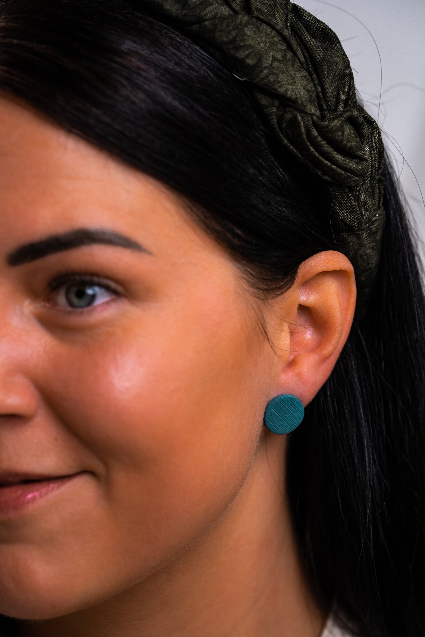 Teal round studs with embossed lines