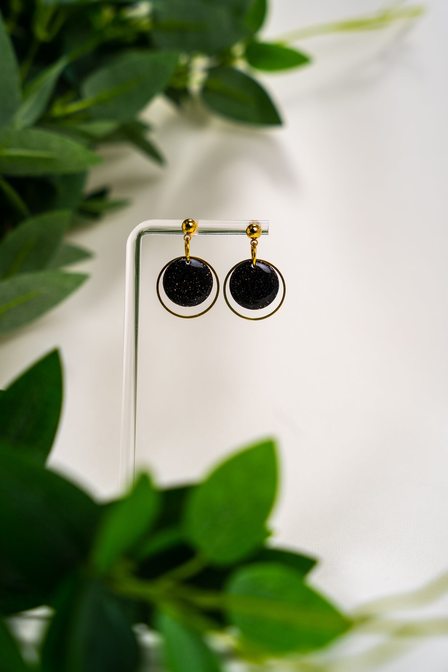 Black round dangle with gold ring
